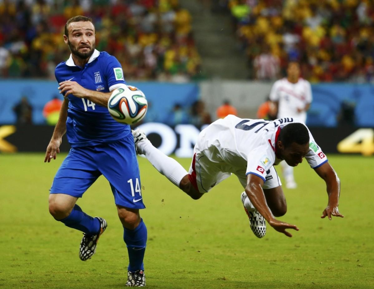 Costa Rica's Diaz falls while fighting for the ball with Greece's Salpingidis during their 2014 World Cup round of 16 game at the Pernambuco arena in Recife Costa Rica vs Greece