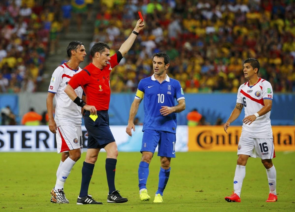 The referee shows the red card to Costa Rica's Duarte as teammate Gamboa walks past during their 2014 World Cup round of 16 game against Greece at the Pernambuco arena in Recife Costa Rica vs Greece