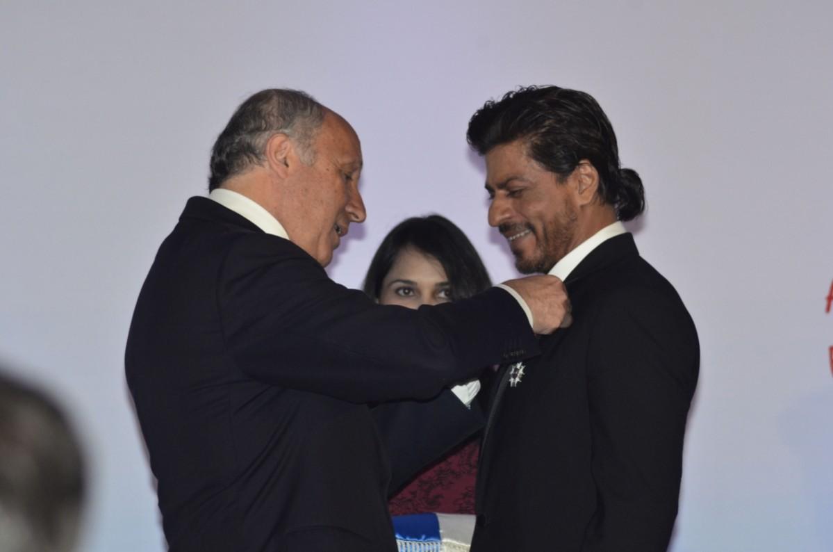 French Foreign Minister Laurent Fabius presents Shah Rukh Khan
