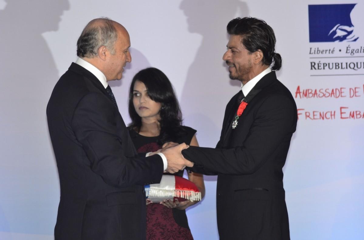 French Foreign Minister Laurent Fabius presents Shah Rukh Khan