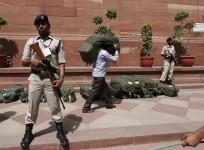 Indian security personnel stand guard near sacks containing the papers of the federal budget for the 2014, 2015 fiscal year, at the parliament in New Delhi