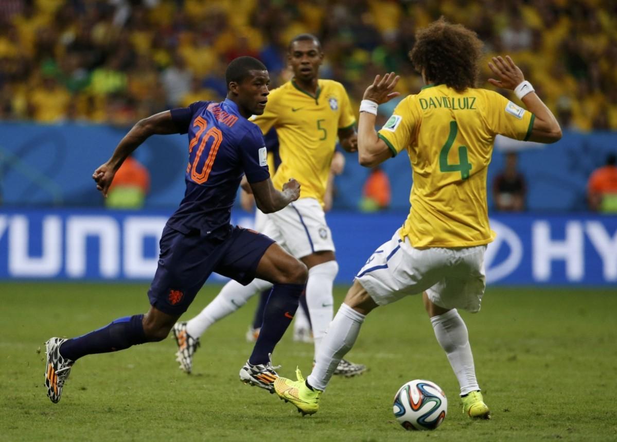Wijnaldum of the Netherlands fights for the ball with Brazil's Fernandinho and Luiz during their 2014 World Cup third-place playoff at the Brasilia national stadium in Brasilia Brazil vs Netherlands