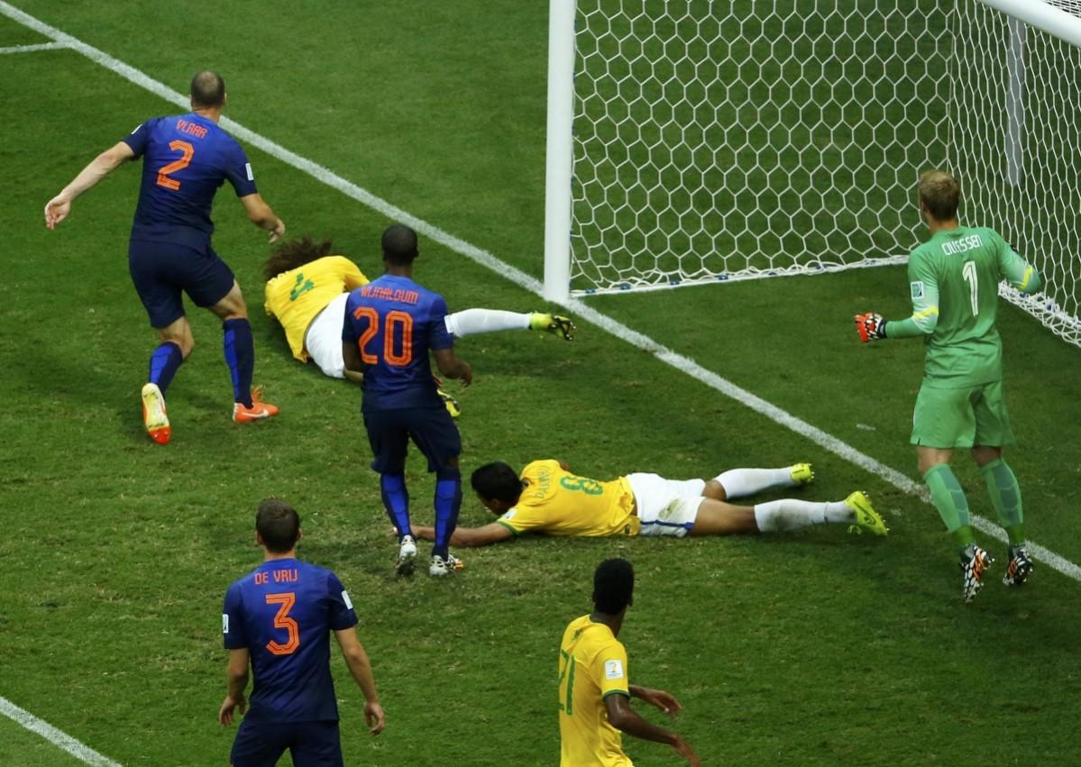 Brazil's Luiz and Paulinho react on the ground after missing an opportunity to score a goal during their 2014 World Cup third-place playoff against the Netherlands at the Brasilia national stadium in Brasilia Brazil vs Netherlands