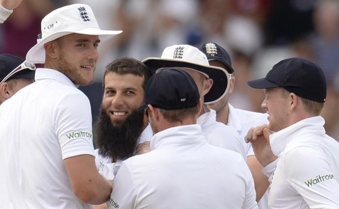 Moeen Ali is congratulated by teammates after the dismissal of India's Shikhar Dhawan. Moeen Ali