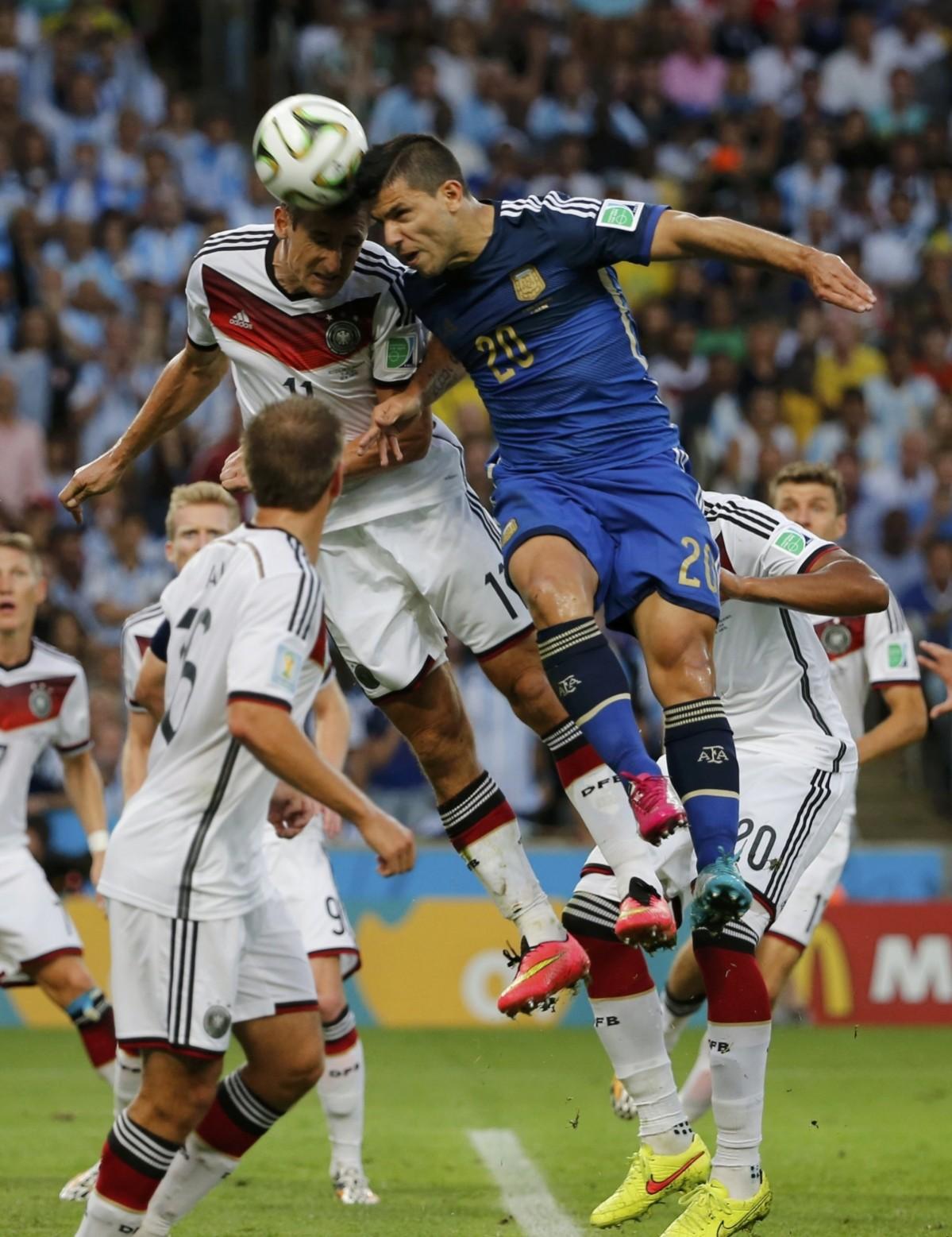 Germany's Klose jumps for the ball with Argentina's Aguero during 2014 World Cup final at the Maracana stadium in Rio de Janeiro. Germany vs Argentina
