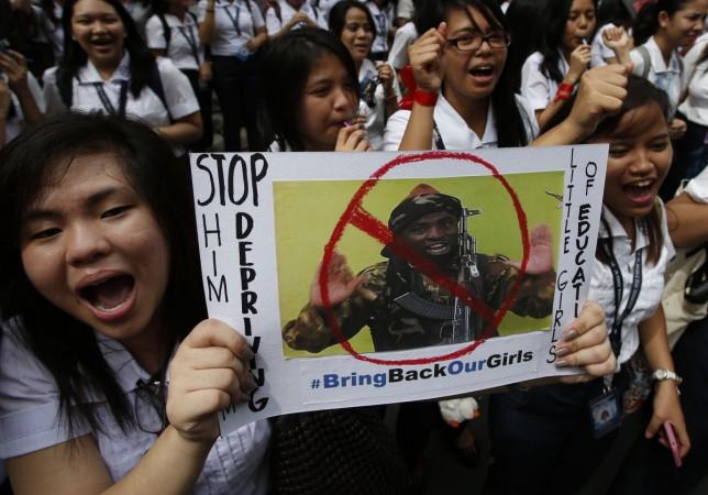 Students from all-girls Catholic school, St Scholastica's College, chant slogans as they display poster of, according to students, a Boko Haram militant during a rally in Manila