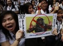 Students from all-girls Catholic school, St Scholastica's College, chant slogans as they display poster of, according to students, a Boko Haram militant during a rally in Manila