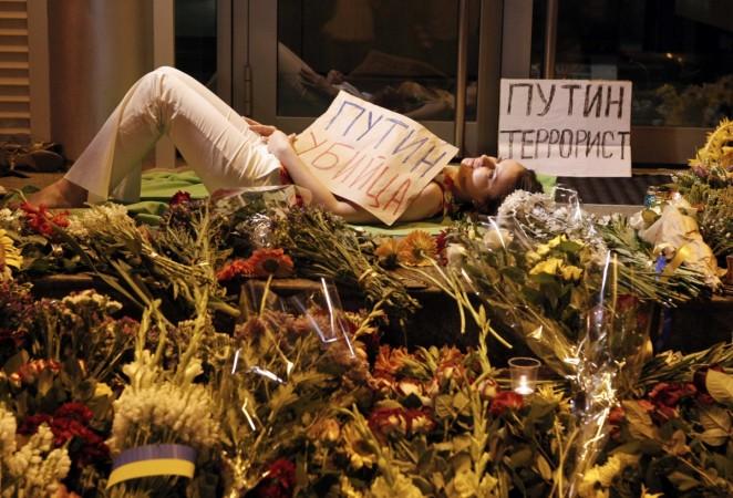 Woman holding a sign that reads  Malaysian Airline MH17 Crash