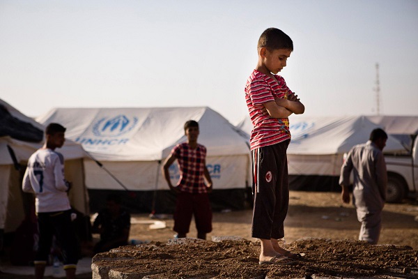 A boy, who fled from the violence in Mosul, stands near tents in a camp for internally displaced people on the outskirts of Arbil in Iraq's Kurdistan region