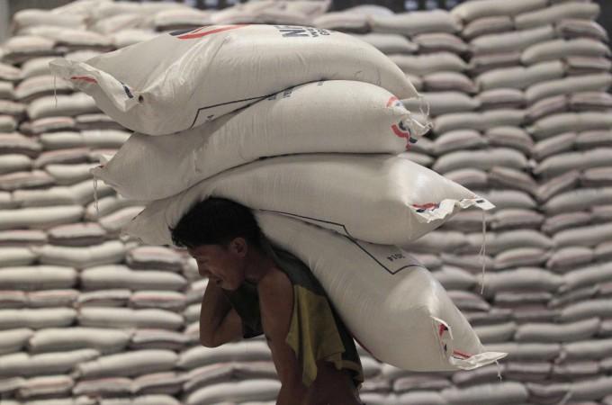 A worker carries sacks of rice