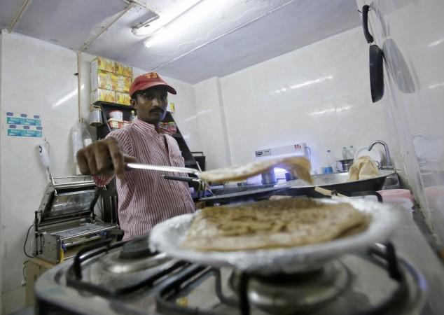 An inmate prepares food inside the kitchen of a restaurant run by Tihar Jail authorities in Delhi