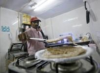 An inmate prepares food inside the kitchen of a restaurant run by Tihar Jail authorities in Delhi