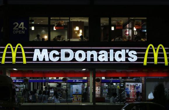 Customers are seen through the windows of a McDonald's store (top) in Tokyo, while others stand in line in front of cash registers, July 22, 2014.