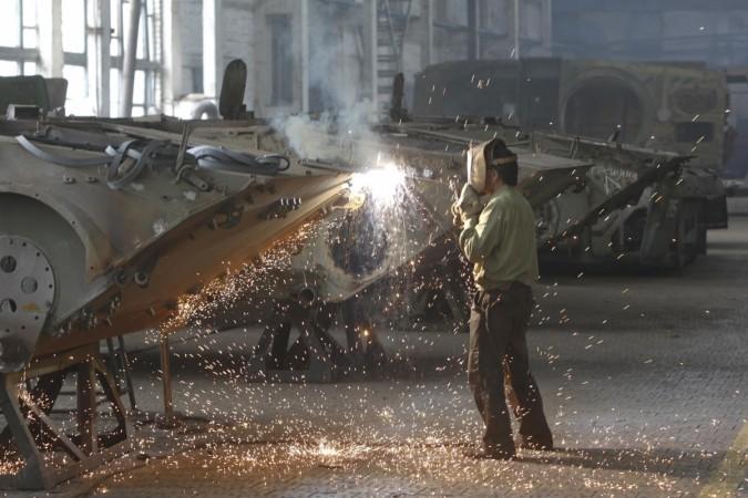 A worker welds at a machinery manufacturing factory