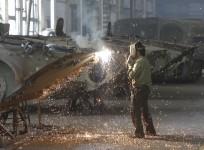 A worker welds at a machinery manufacturing factory