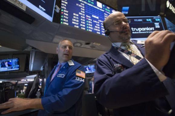 Specialist trader Geoffrey Friedman (L) gives a price just after the opening bell on the floor of the New York Stock Exchange July 21, 2014. New York Stock Exchange