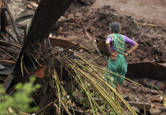 A resident looks at the debris of her damaged house after a landslide at Malin village in the western Indian state of Maharashtra July 30, 2014. Pune Landslide