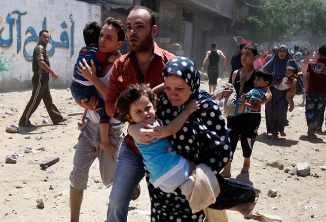 A Palestinian family runs for cover during an Israeli shelling