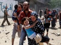 A Palestinian family runs for cover during an Israeli shelling