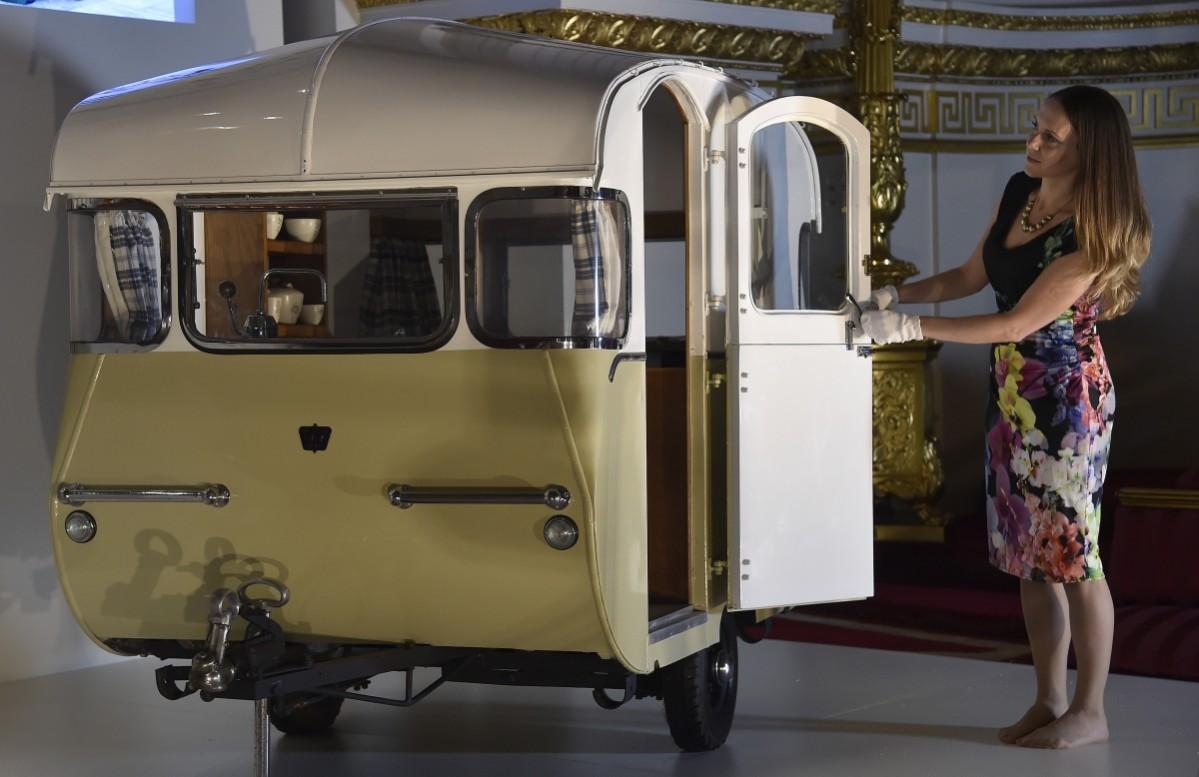 Curator of the Royal Collection Trust Anna Reynolds with a miniature caravan, presented by the Caravan Club to Prince Charles and Princess Anne in 1955, at Buckingham Palace - the official residence of Britain's Queen Elizabeth - in central London. Royal Childhood Exhibition