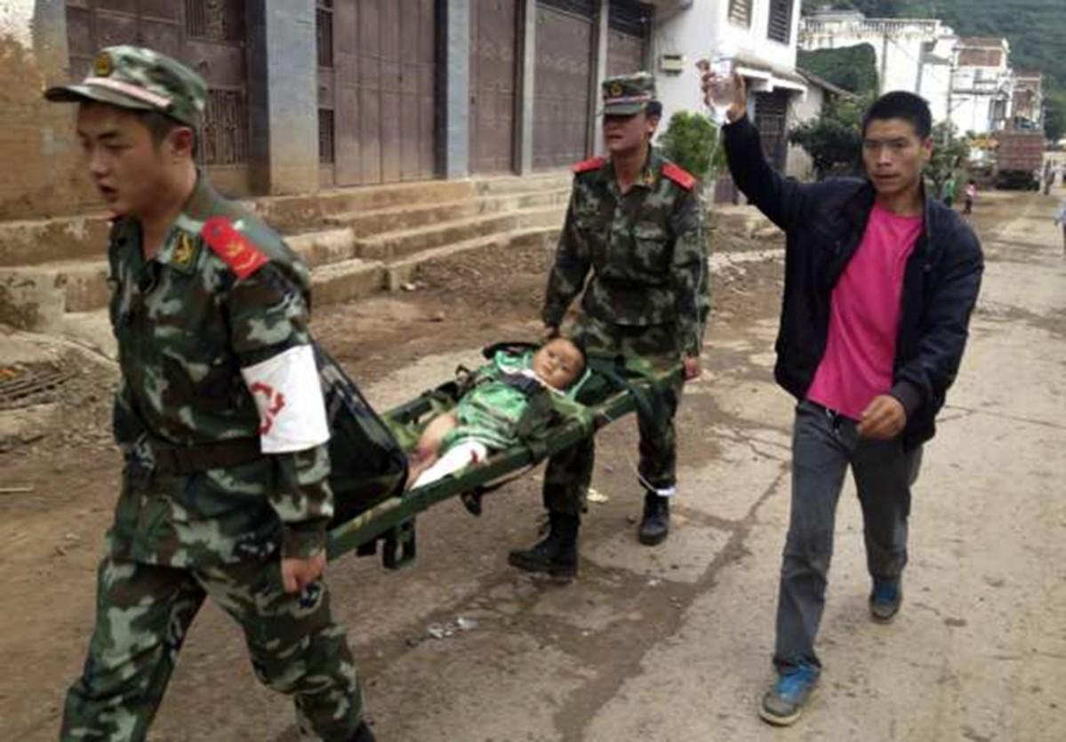 The policemen rescued a child from the quake-hit Yunnan province. China Earthquake
