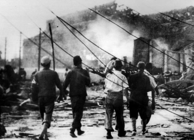 FILE PHOTO TAKEN 06AUG1945 - Japanese air raid workers carry a victim of the atomic bomb in Hiroshima away from smoking ruins in this August 6, 1945 file photo. Hiroshima bombing