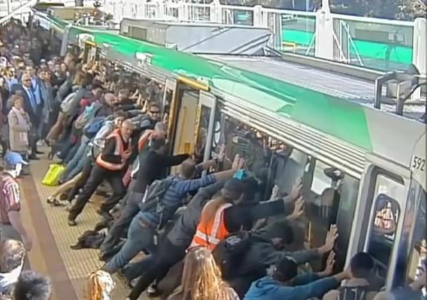 Passengers push train to save man trapped under it Passengers push train to save man trapped under it