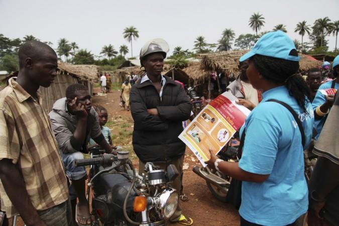 A UNICEF worker speaks with drivers of motorcycle taxis about the symptoms of Ebola virus disease (EVD) and best practices to help prevent its spread, in the city of Voinjama, in Lofa County, Liberia. Ebola