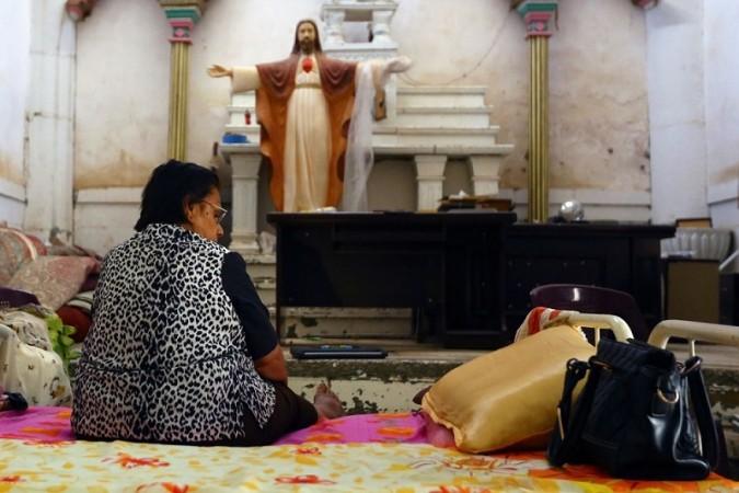 An Iraqi Christian woman, fleeing the violence in the city of Mosul, sits inside the Sacred Heart of Jesus Chaldean Church in Telkaif.