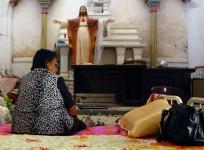 An Iraqi Christian woman, fleeing the violence in the city of Mosul, sits inside the Sacred Heart of Jesus Chaldean Church in Telkaif.