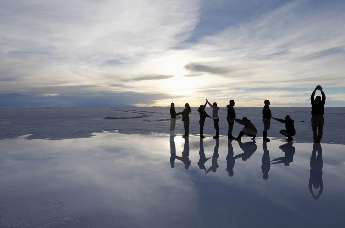Tourists stand on the Salar salt lake of Uyuni before the seventh stage of the Dakar Rally 2014, that will run from Salta to Uyuni, January 11, 2014 Unbelievable Places in the world
