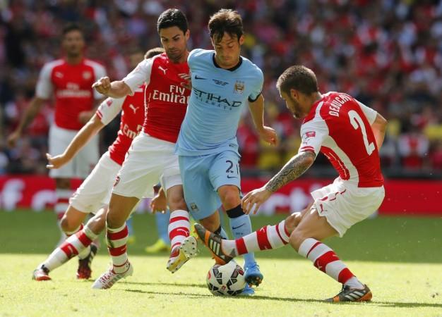 David Silva is tackled by Arsenal's Mikel Arteta and Mathieu Debuchy during their Community Shield tie David Silva