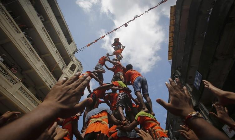 Devotees try to form a human pyramid to break a clay pot containing butter during celebrations for Janmashtami in Mumbai Dahi Handi
