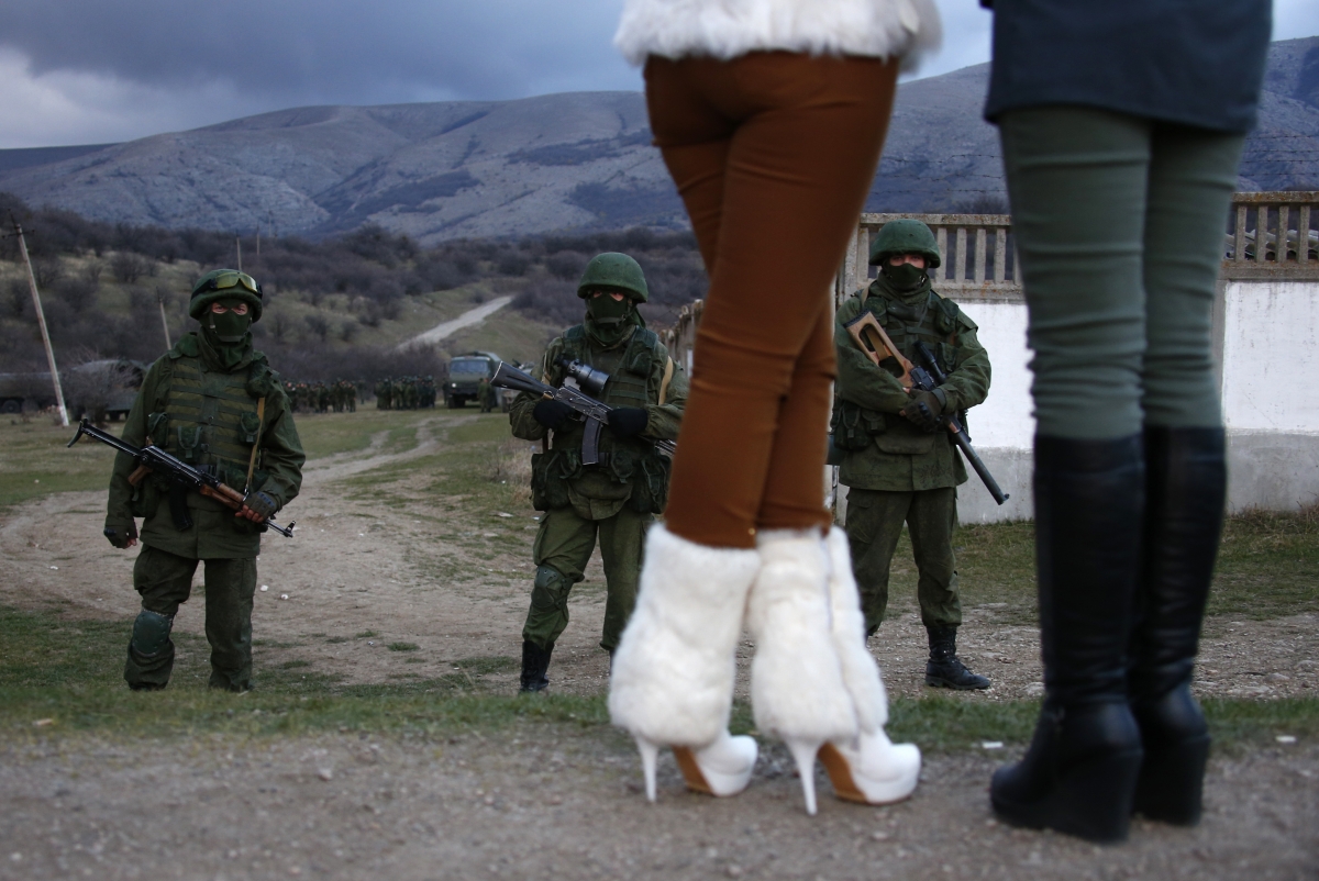 Perevalnoe, Ukraine
Local women watch armed men, believed to be Russian soldiers, assemble near a Ukrainian military base in Perevalnoe March 5, 2014. World Photography day