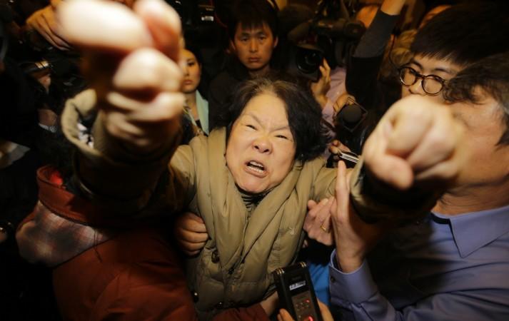 A family member of a passenger aboard Malaysia Airlines MH370 shouts at journalists after watching tv boradcast World Photography day