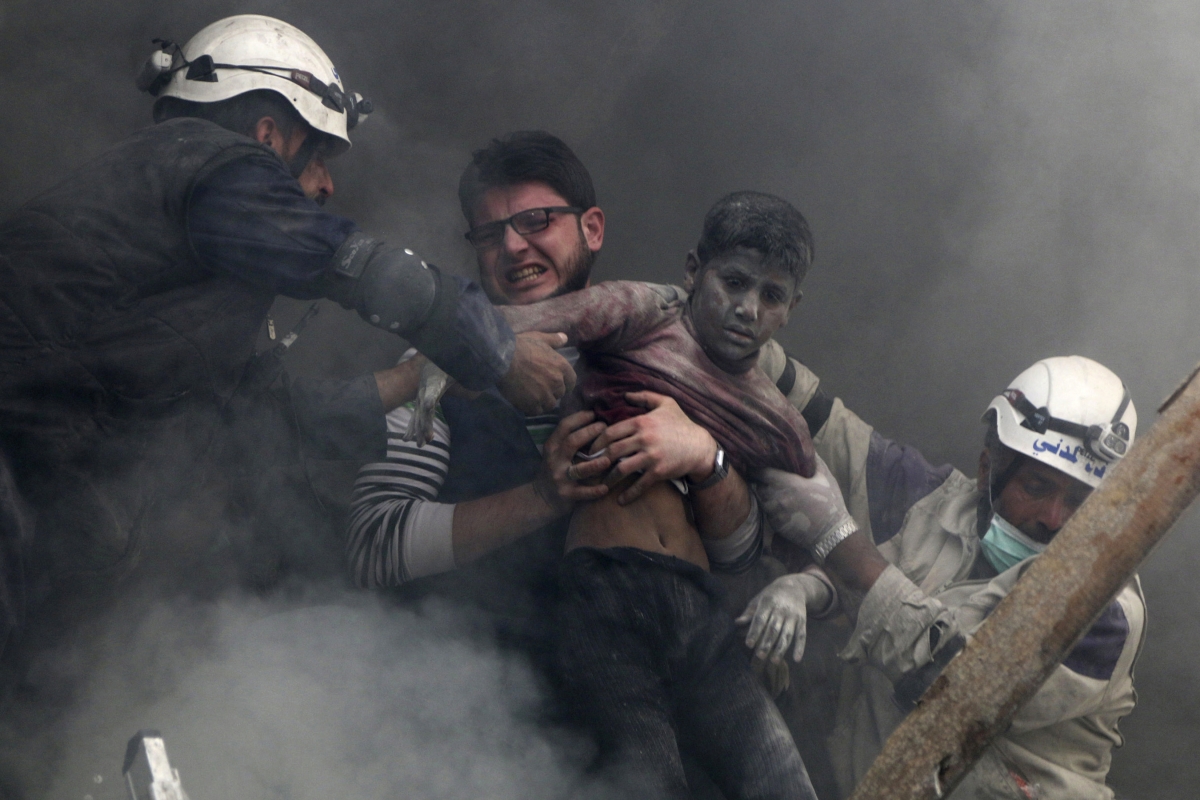 Men rescue a boy from under the rubble after what activists said was explosive barrels dropped by forces loyal to Syria's President Bashar Al-Assad in Al-Shaar neighbourhood of Aleppo April 6, 2014. World Photography day
