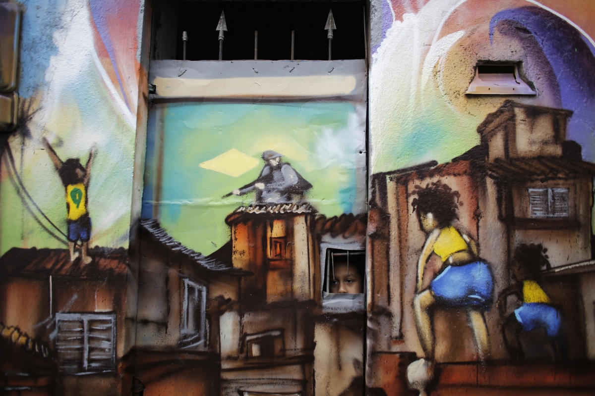 A child looks out from the window of his home painted with graffiti by members of OPNI, in reference to the 2014 World Cup, in the Vila Flavia slum of Sao Paulo May 28, 2014. The OPNI , a Portuguese acronym which means World Photography day