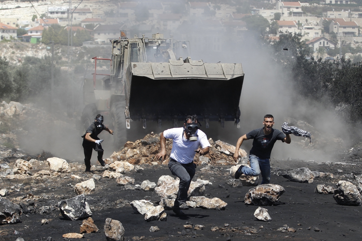 Representational Image: Protesters run in front of an Israeli military bulldozer during clashes with Israeli troops following a protest against the nearby Jewish settlement of Qadomem, in the West Bank village of Kofr Qadom, near Nablus, June 27, 2014. World Photography day