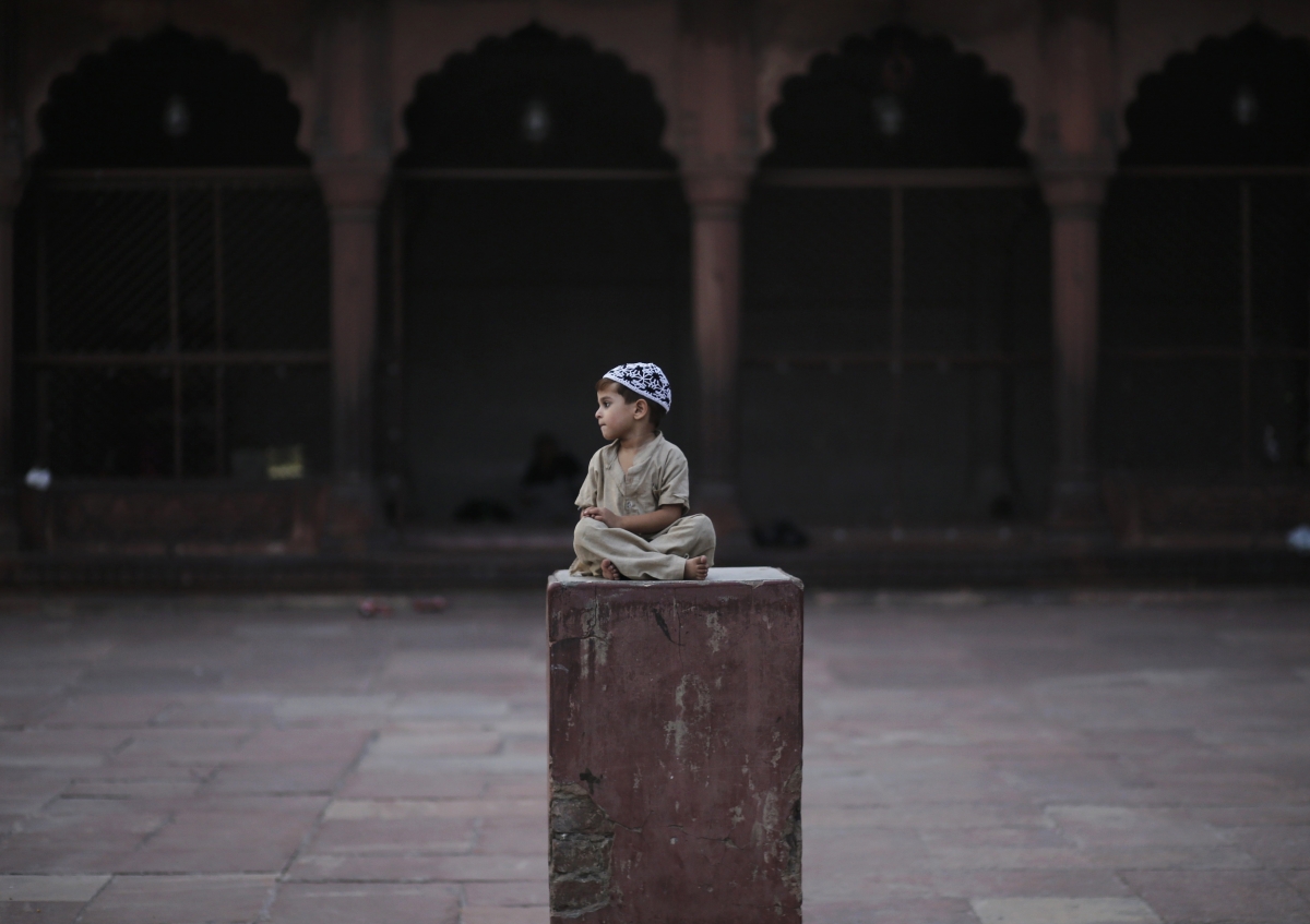 Delhi, India
A Muslim boy sits on a plinth before the Iftar (breaking of fast) meal, during the holy fasting month of Ramadan at the Jama Masjid (Grand Mosque) in the old quarters of Delhi July 1, 2014. World Photography day
