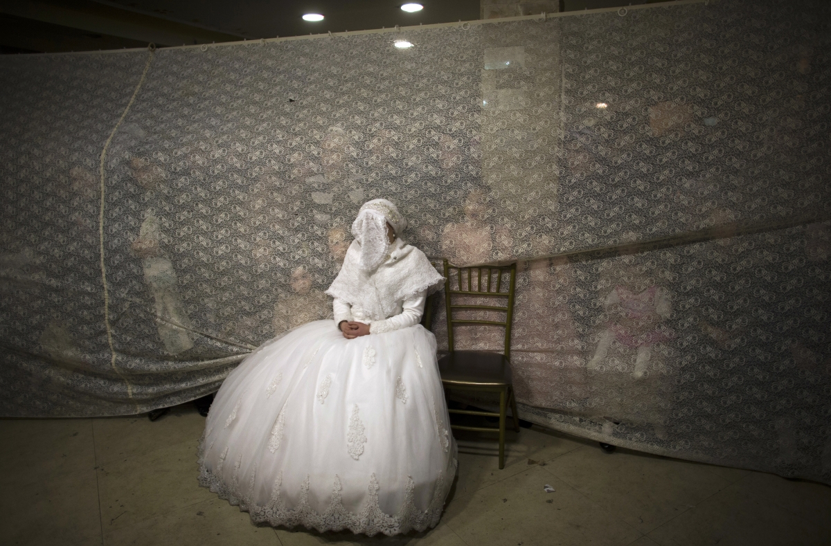 Jerusalem, Israel
Ultra-orthodox Jewish bride Rivka Hannah Krois watches her groom dance after their traditional wedding ceremony in the Mea Shearim neighbourhood of Jerusalem early February 19, 2014. World Photography day