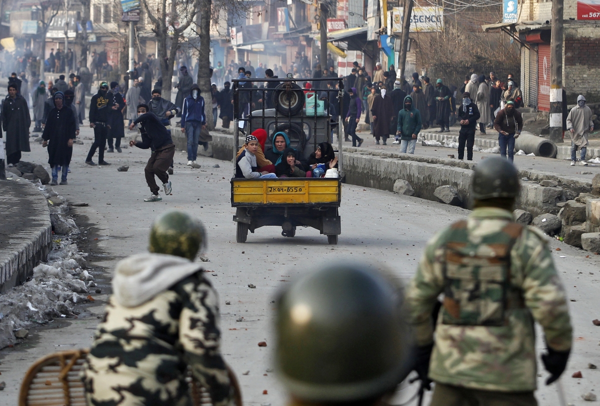 Srinagar, India
A three-wheeler carrying a family moves past a Kashmiri protester throwing a stone towards the Indian security personnel during a protest in Srinagar January 31, 2014. Shops and other business establishments remained closed in Srinagar on Friday following a shutdown called by the separatists to protest against Indian Army's decision to close an alleged fake encounter case against five soldiers in connection with the killings of five civilians in March 2000 at Pathribal, in south of Srinagar, local media reported. World Photography day