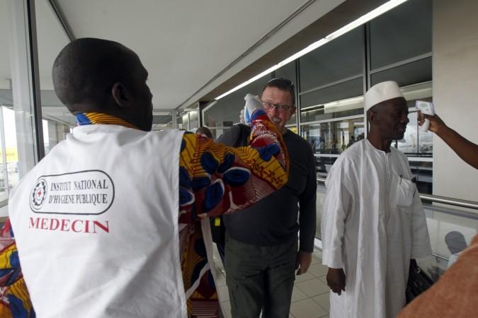 Health workers take passengers' temperatures with infrared digital laser thermometers at the Felix Houphouet Boigny international airport in Abidjan, Ivory Coast. Ivory Ebola