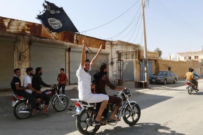 A resident of Tabqa city touring the streets on a motorcycle waves an Islamist flag in celebration after Islamic State militants took over Tabqa air base, in nearby Raqqa city August 24, 2014. I