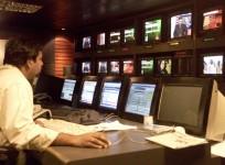A news producer sits inside a news studio