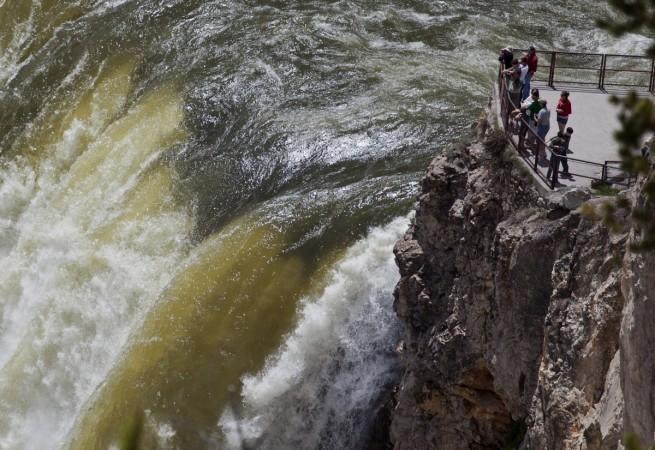 YELLOWSTONE FALLS: People stand at the brink of the 93-meter tall Yellowstone River Lower Falls in Yellowstone National Park, Wyoming, United States. Spectacular Waterfalls in the World