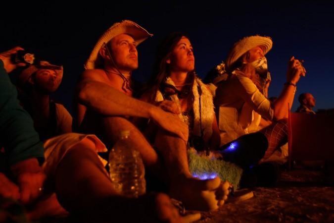 Festival-goers watch as the effigy of The Burning Man lights up after the fireworks Festival-goers watch as the effigy of The Burning man lights up after the fireworks