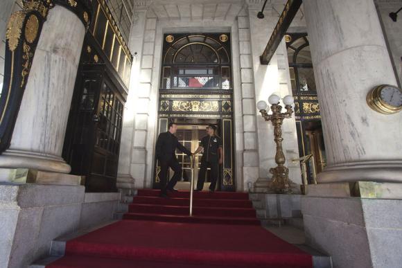 Employees stand at the main entrance to the Plaza Hotel in the Manhattan borough of New York August 18, 2014