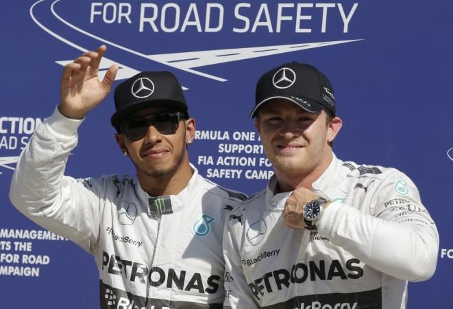 Mercedes Formula One driver Lewis Hamilton of Britain (L) waves next to his team mate Nico Rosberg of Germany after getting the pole position for the Italian F1 Grand Prix in Monza September 6, 2014. Lewis Hamilton and Nico Rosberg