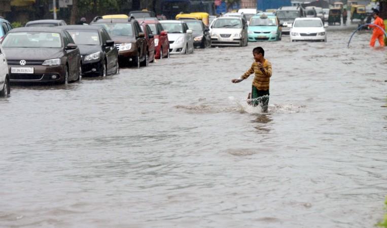 A boy enjoys rain in the national capital. Heavy rain brought a relief to Delhiites on THursday as the temperature in the region slashed from 34 degrees Celsius to 25.4 degree celsius. New Delhi