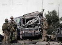 The US troops keep watch near a damaged vehicle at the site of suicide attack in Kabul September 16, 2014.